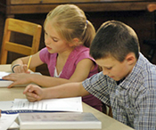 girl and boy student writing